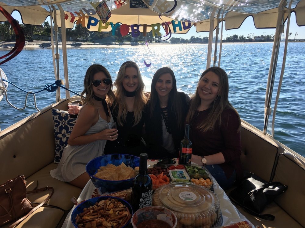 Birthday party celebration on a Duffy boat with Happy Birthday banner