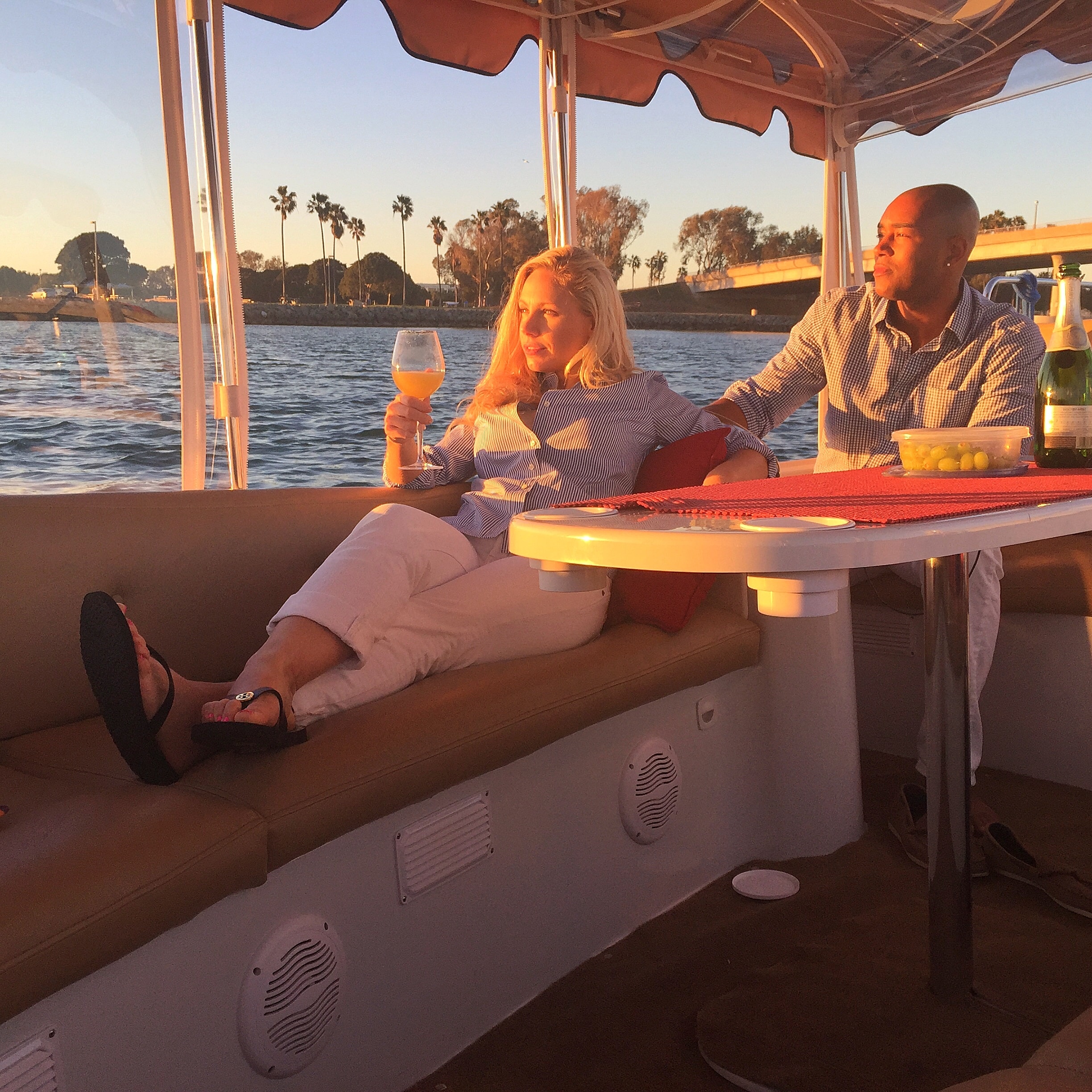 Couple dining on a Duffy boat at sunset